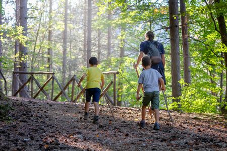 Villetta Barrea (AQ), Italy - September 29, 2019: hiker with two small children walks on the mountain path in the woods, in nature.のeditorial素材