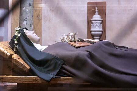 Assisi, Italy - December 7, 2019: Inside the church there is the original crypt with the remains of St. Clare, enclosed in a body-reliquary, which lies inside a crystal urn.のeditorial素材