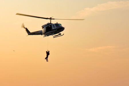 Trieste, Italy - September 27, 2009: Italian police helicopter with divers anchored to the rope, for the transport of men overboard.のeditorial素材