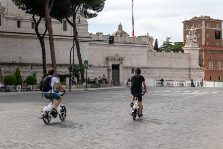 Rome, Italy - May 10, 2020: Viale dei Fori Imperiali, first exit of citizens after the end of the restrictions for the Covid-19 pandemic. People stroll on the streets or ride bicycles wearing protective masks.のeditorial素材
