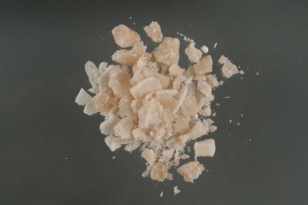 Crack, a type of drug obtained through chemical processes from cocaine. Amazing substance in small pieces. Crack is produced by dissolving powdered cocaine in a mixture of water and ammonia or sodium bicarbonate (baking soda). The mixture is boiled until a solid substance forms. The solid is removed from the liquid, dried, and then broken into the chunks (rocks) that are sold as crack cocaine. The name "crack" refers to the sound generated during its manufacture and when smoked. Street names include: rock, hard, iron, cavvy, base, or just crack.の写真素材