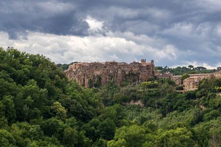 Panoramic view of the village of Calcata, in the province of Viterbo, Italy. Medieval village built entirely of tuff and immersed in the green of the surrounding woods.の写真素材