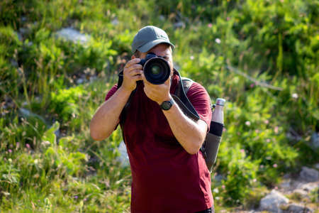 Mountain hiker photographer explores the area for the photographic hunting of wild animals. The man...