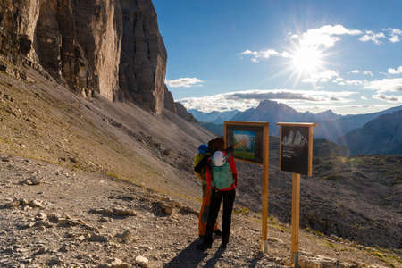 Auronzo di Cadore, Belluno, Italy - August 05, 2020: On the Forcella Lavaredo in the Tre Cime natural park, two hikers look at the signpost with the map of the dolomites of that territory.のeditorial素材