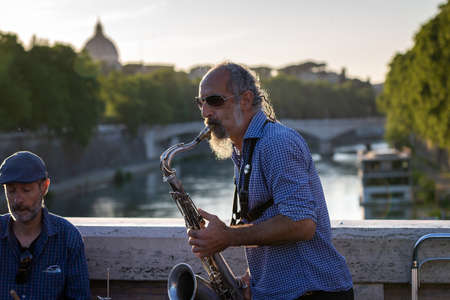Rome, Italy - May 26, 2021: Street musicians entertain passersby as they play their musical instruments on a bridge across the Tiber River.のeditorial素材