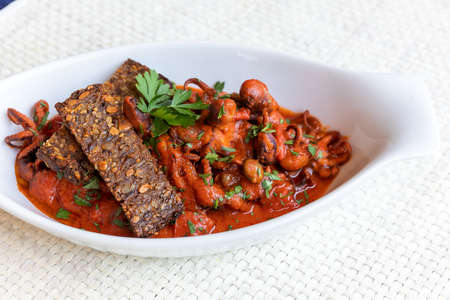 Octopus Luciana style, so called from the popular village of Santa Lucia, where there was a fishing community, are a typical recipe of Neapolitan cuisine. Octopuses are cooked with tomato, olives.の写真素材