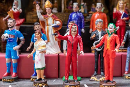 Naples, Italy - December 24, 2021: Hand painted terracotta statuettes, representing famous people,...