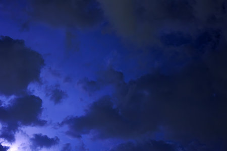 The clouds move fast across the dark night sky, the flashes of light from the approaching storm...