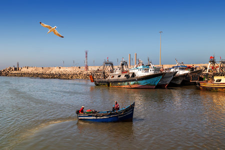 Essaouira, Morocco - August 2, 2023: A small boat returns to the port after sea fishing.のeditorial素材