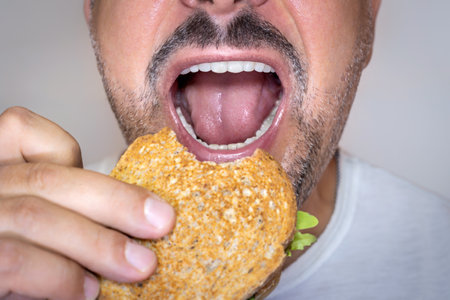 Close-up of man eating cheese toast.の写真素材