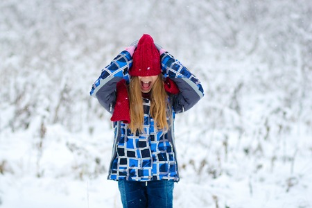Portrait teen girl in winter forest red hat
