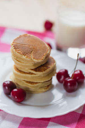 Tasty Pancake with fresh cherries on a white plateの写真素材
