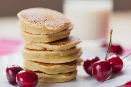 Tasty Pancake with fresh cherries on a white plateの写真素材