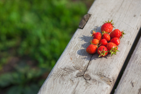 Ripe strawberries on a wooden background in the villageの写真素材