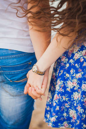 Young couple holding hands. Close up outdoorの写真素材