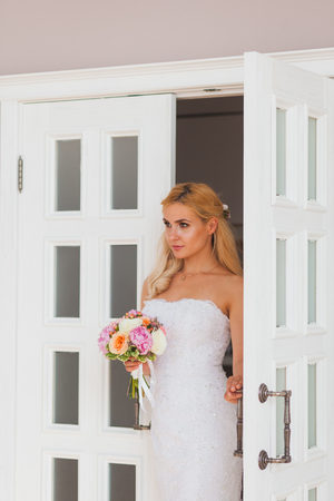 Portrait of a beautiful blonde bride with bouquet, wedding conceptの写真素材