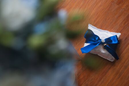 Wedding rings on a white cushion with blue bow. Wedding in blueの写真素材