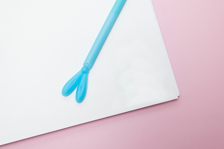 top view of a open notebook with a blue pen on a pink background. Place for text, mockup for designの写真素材