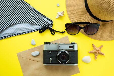 Vintage camera, hat, swimsuit, sunglasses on a yellow background. Summer concept. Flatlay, copyspaseの写真素材