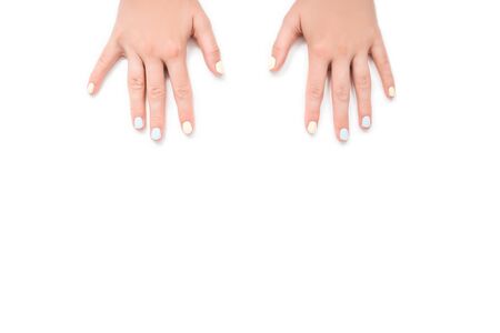 Close up hand with fresh trendy neon light blue and yellow color manicure on white isolated background.の写真素材