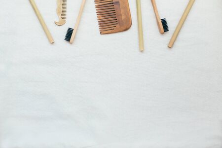 Ecological reusable zero waste items: bamboo toothbrushes and straws, wooden and metal brushes, textile eco bag on white linen background. Flat lay style.の写真素材