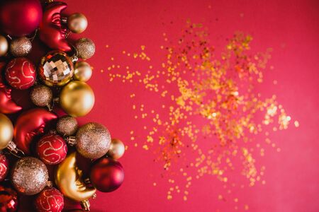 Festive red and gold Cristmas tree decorations on red background. Flat lay style. Place for text.の写真素材