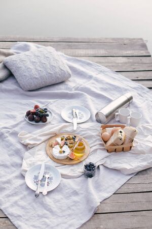 Picnic on the lake: fresh eggs, sandwiches from ciabatta with olives, camembert cheese with figs and nuts decorated with blueberries. Breakfast on fresh air.の写真素材