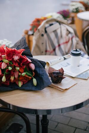 Still life with fresh coffee and chocolate muffin standing on table in cozy street cafe.の写真素材