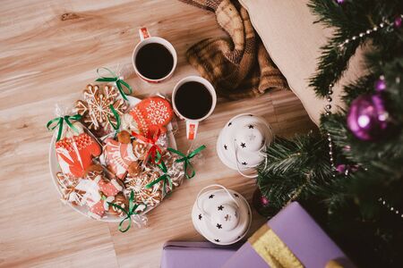 Two cups of tea with fresh home made gingerbread under Christmas tree.の写真素材