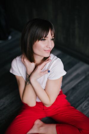 Portrait of young beautiful woman posing on black background.の写真素材