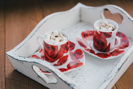 Two cups of hot cocoa with marshmallows and cinnamon on wooden background. Valentine's Dayの写真素材