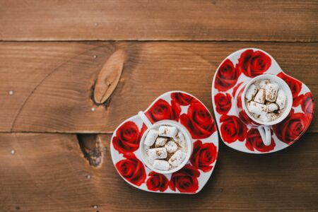 Two cups of hot cocoa with marshmallows and cinnamon on wooden background. Valentine's Dayの写真素材