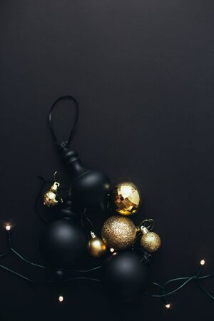 Vintage Christmas black and golden decorations and festive lights on black background.の写真素材