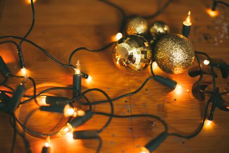 Close up vintage Christmas decorations and festive lights on wooden background.