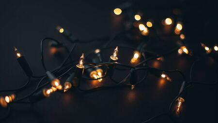Golden Christmas garland on black background close up.の写真素材