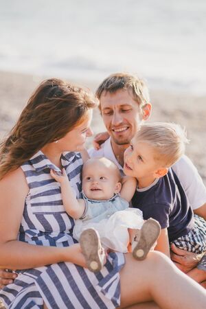 Happy family with two kids having fun near sea at the beach.の写真素材