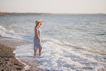Happy plus size woman relaxing near ocean at the beach on sunny day.の写真素材