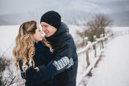 Young happy couple spending holiday weekend in a winter snowy countrysideの写真素材