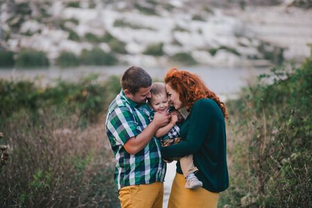 Happy family of mother, father and son having good time in a spring green park.の写真素材