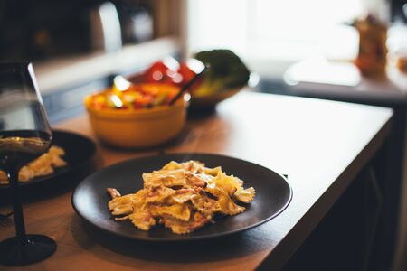 Fresh hot steaming pasta on wooden table on cozy kitchen. Home made dinner.の写真素材