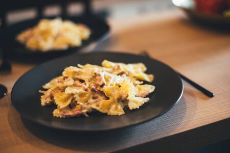 Fresh hot steaming pasta on wooden table on cozy kitchen. Home made dinner.の写真素材
