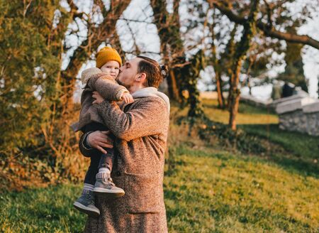 Stylish father hipster with beard and tattoo walking with his little daughter. Fashion family look.の写真素材