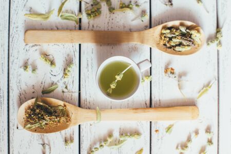 Natural organic herbal green tea in wooden spoons on white vintage background.の写真素材