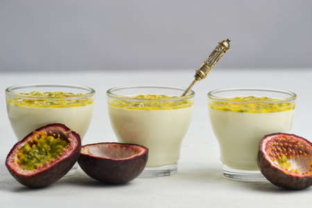Tasty Italian dessert panna cotta with fresh passion fruits on light background. Copy spaceの写真素材