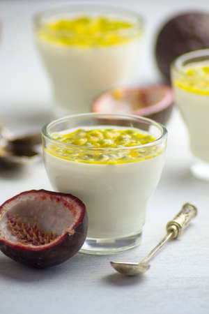 Tasty Italian dessert panna cotta with fresh passion fruits on light background. Copy spaceの写真素材