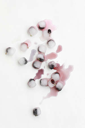 Ice cubes with blue berry fruits on white background. Frozen fruits, melting ice cubes, top view, mock up.の写真素材