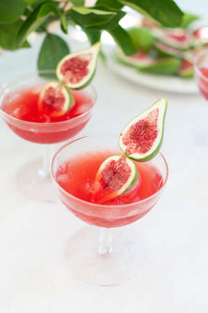 Red drink with ice. Alcoholic beverages decorated with fresh fig fruits on white background. Campari aperol drinkの写真素材