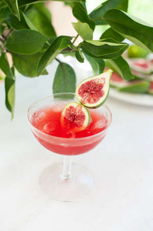 Red drink with ice. Alcoholic beverages decorated with fresh fig fruits on white background. Campari aperol drinkの写真素材