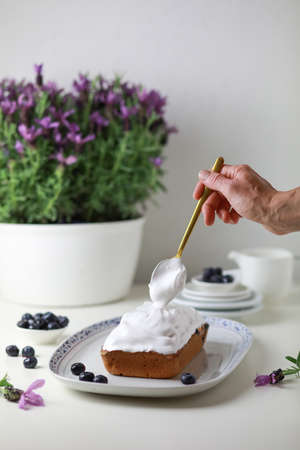 Woman decorating bundt cake with glazing, close-up view of hand decorating the cake.の写真素材