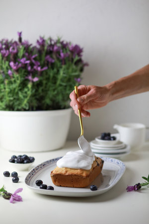 Woman decorating bundt cake with glazing, close-up view of hand decorating the cake.の写真素材